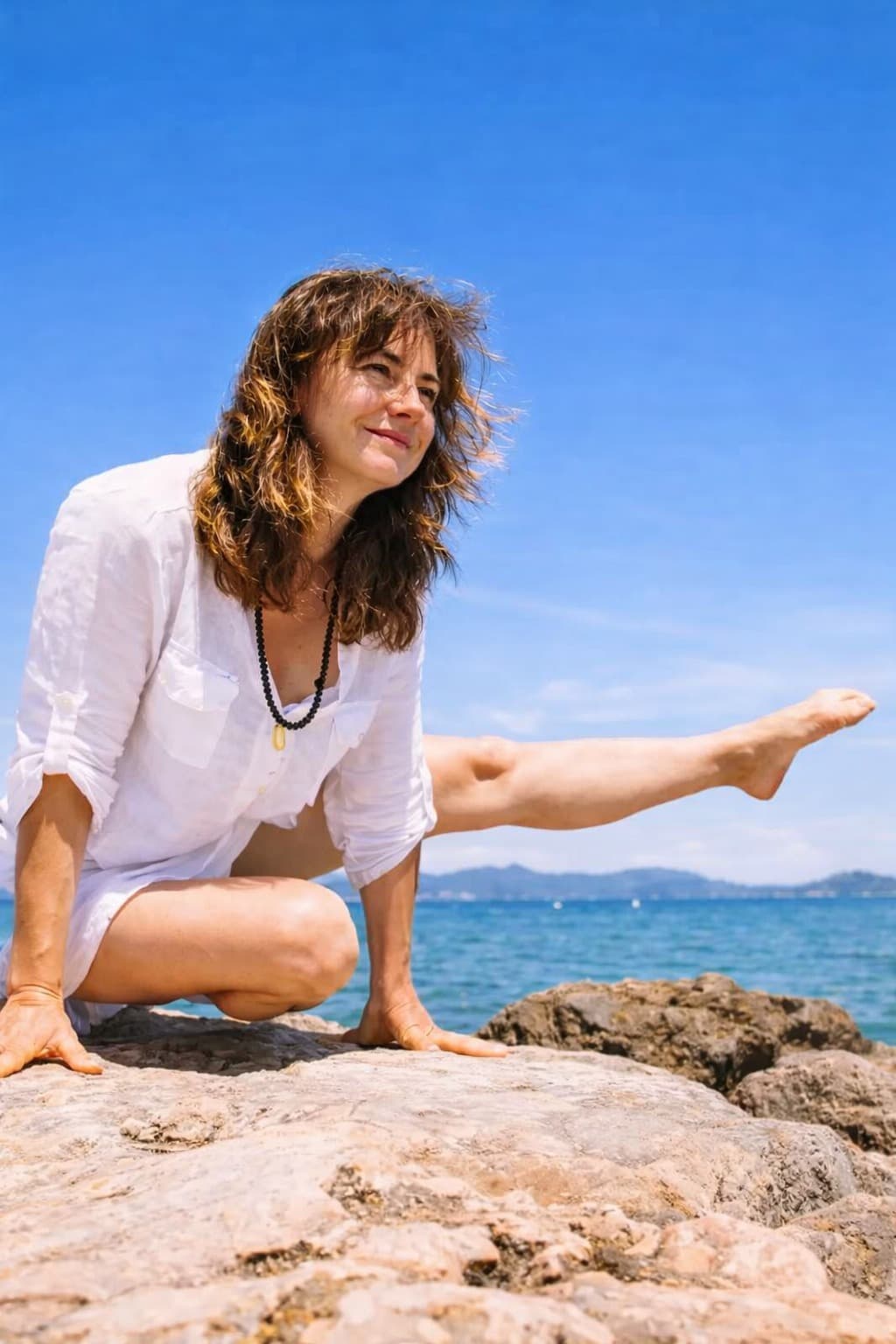 Tina Mastandrea in pratica yoga sugli scogli, davanti al mare
